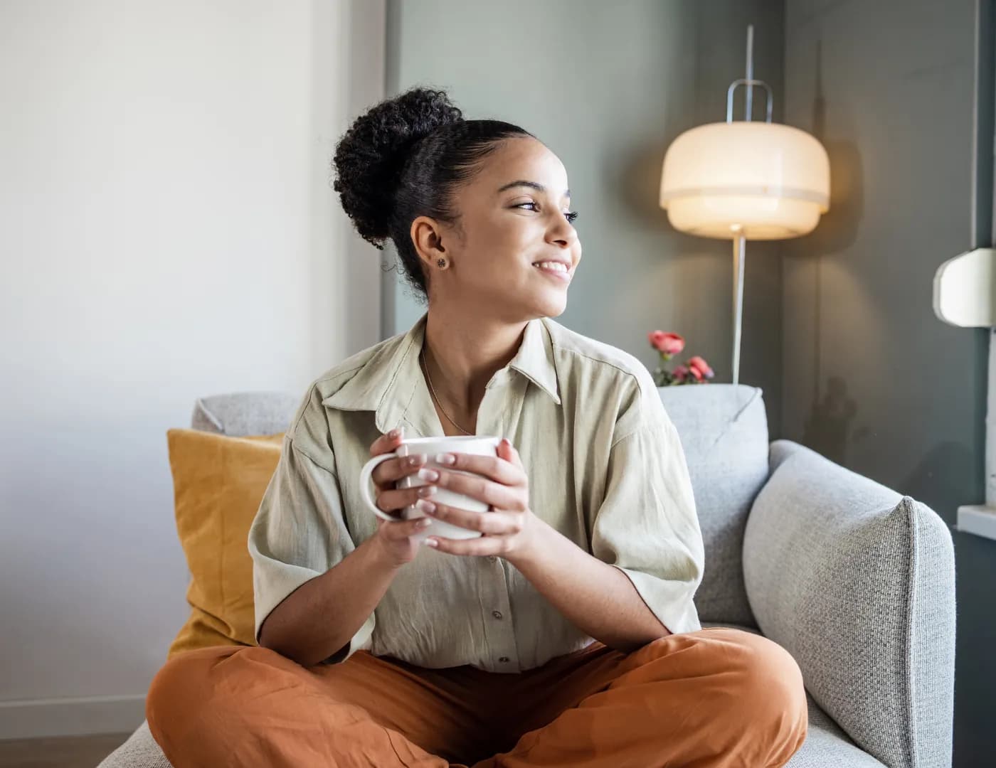 An employee relaxing on a sofa with a warm drink, the calm an EAP promises