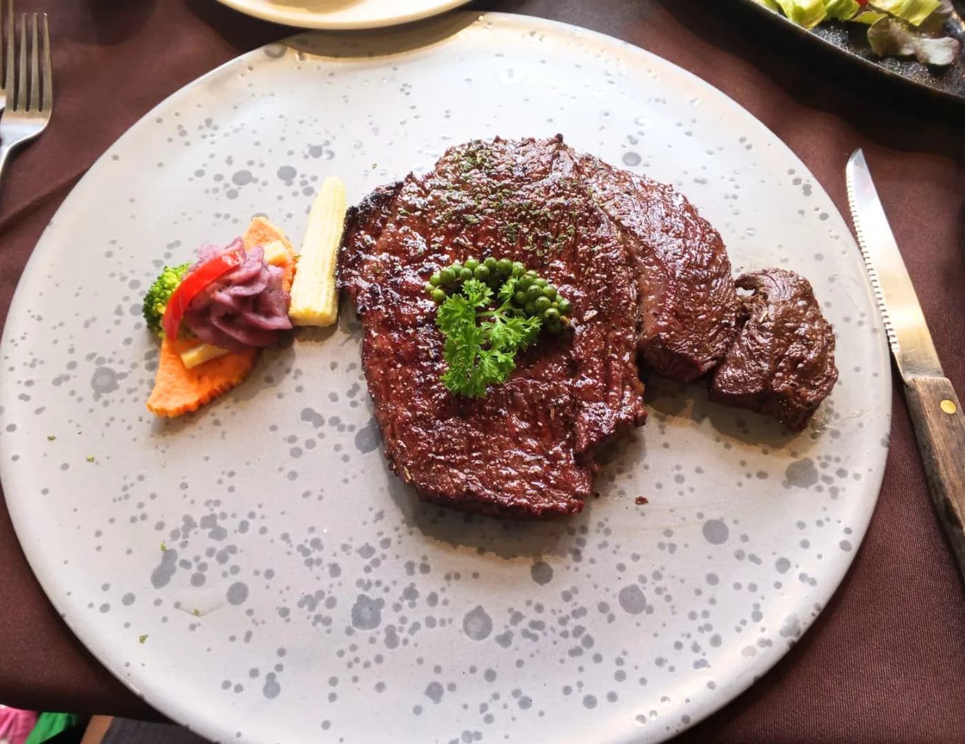 Grilled steak served with a side of dressed green salad