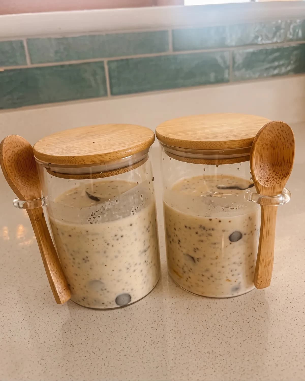 Two jars of overnight oats with wooden spoons