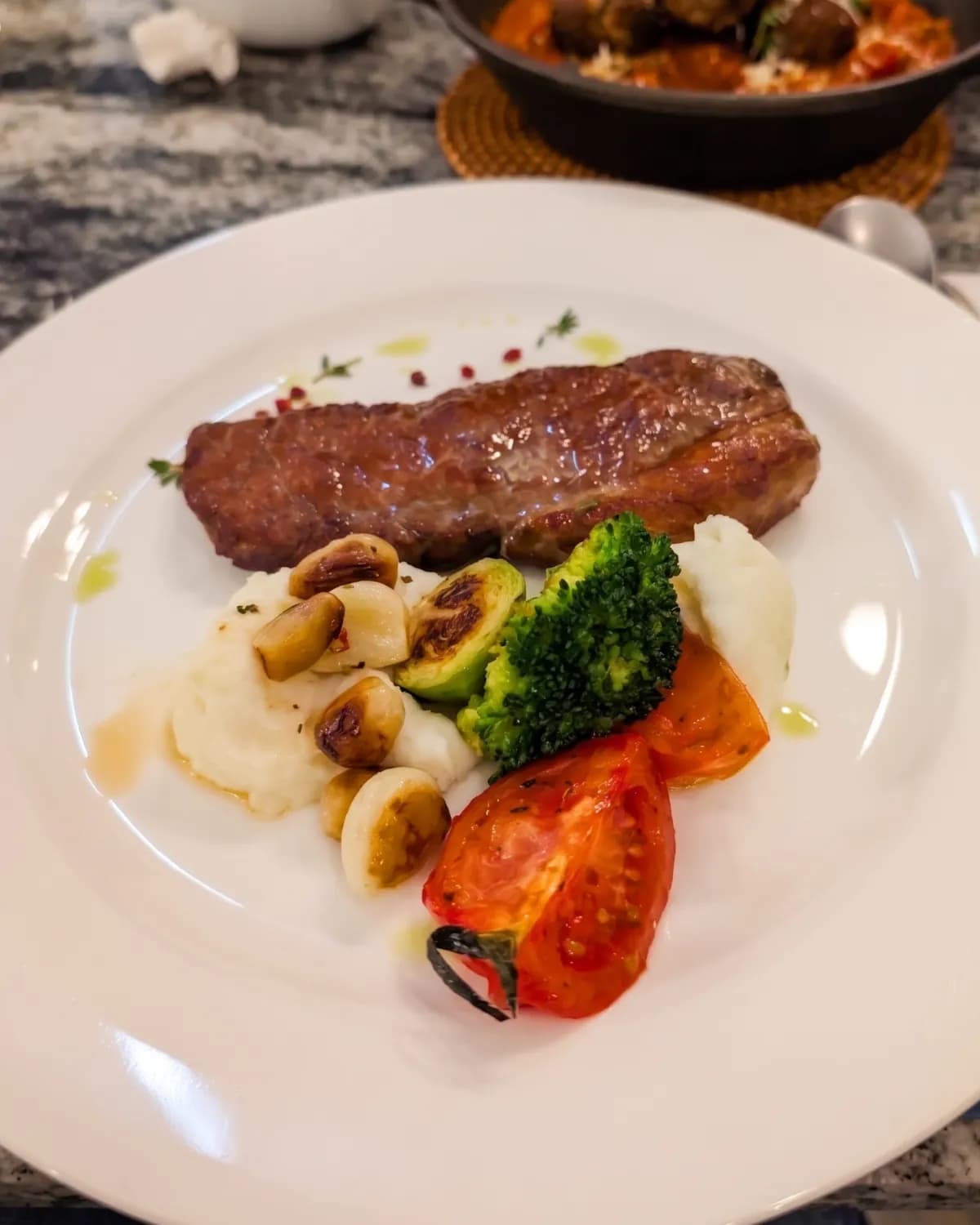 Plate of grilled sausage with mashed potato, mushrooms, broccoli and roasted tomato